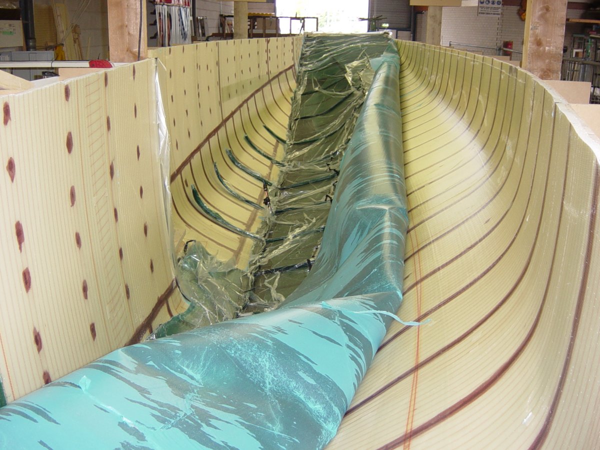 Releasing the infusion consumables after the controlled vacuum infusion of the interior laminate of a main hull half