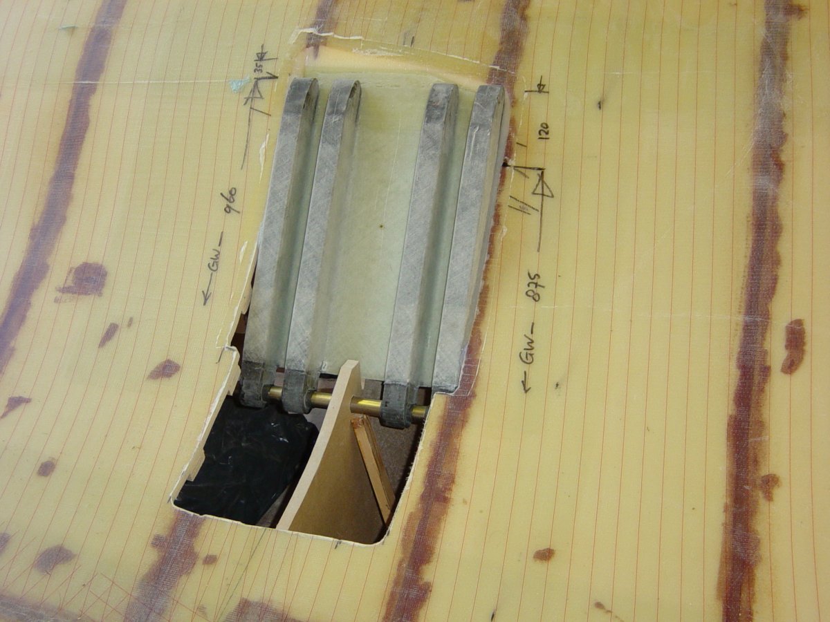 Carbon lower folding strut anchor assembly positioned in the first main hull half and aligned with a temporary pivot pin through the form frame