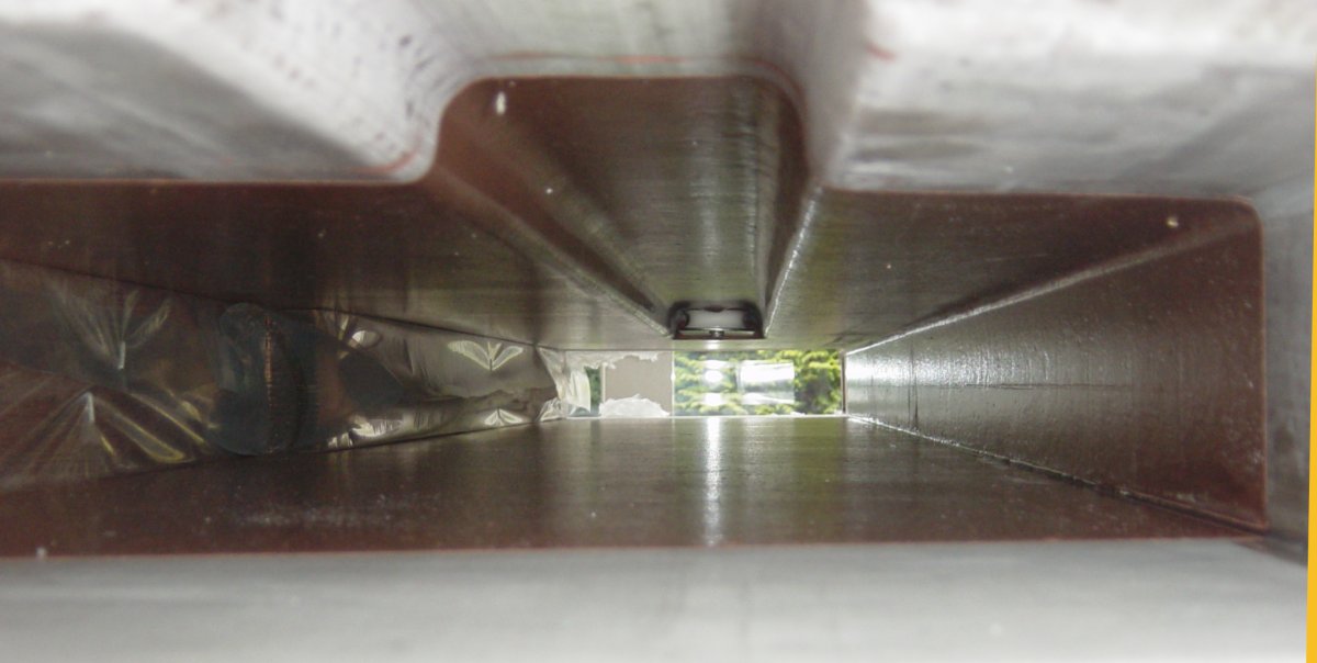 Marine plywood daggerboard case under construction, showing the laminated case halves and internal coating work