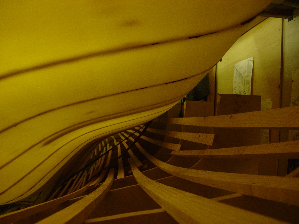 Starboard main hull half after unmoulding, turned upright in the workshop with minimal clearance